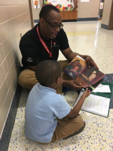 Leading Men Fellow Torren Cooper reading a story with a Pre-K student