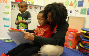 Pre-K tutor completing sign-in intervention with a student