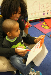 Pre-K tutor completing sign-in intervention with a student