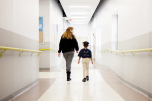 DC K-3 tutor walking down the hallway with a student